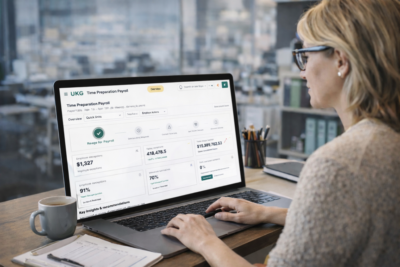 Payroll administrator reviewing the UKG payroll preparation overview with readiness, exceptions, and key insights on a laptop